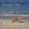 GW16275-50 = Scene on Es Trenc beach ( Platja de Trenc) in SE Mallorca ( girl in straw hat and bikini sitting on beach chair by waters edge ), Baleares, Spain.