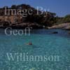 GW19575-50 = Small Cala Es Moquer viewed from adjacent Cala S'Almunia ( lady swimming ), near Urbanisation Cala Llombards, SE. Mallorca, Balearic Islands, Spain.