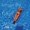 GW25030-50 = Young bikini clad lady floating on a lilo in the swimming pool of a country finca, Mallorca, Balearic Islands, Spain.