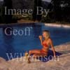 GW25570-50 = Young bikini clad lady enjoying a bucks fizz by the side of the swimming pool of a country finca, Mallorca, Balearic Islands, Spain.