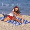 GW30776-60 = Young lady performing pre swim yoga, fitness, exercise and meditation at Puerto Alcudia beach, North East Mallorca, Balearic Islands, Spain. 11th November 2007. Model Release.