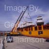 GW32210-60 = Prepare for lift off - Johnson 105 luxury motor yacht / superyacht awaiting discharge from container vessel "OPDR Tanger" with two heavy lift cranes in attendance, in the Port of Palma de Mallorca, Balearic Islands, Spain. 7th April 2008.