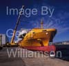 GW32260-60 = Johnson 77 luxury motor yacht / superyacht during lift off from container vessel "OPDR Tanger" - with two heavy lift cranes in attendance and the historic Porto Pi lighthouse in the background - in the Port of Palma de Mallorca, Balearic Islands, Spain.8th April 2008.