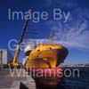 GW32265-60 = Johnson 77 luxury motor yacht / superyacht during lift off from container vessel "OPDR Tanger" - with two heavy lift cranes in attendance and the historic Porto Pi lighthouse in the background - in the Port of Palma de Mallorca, Balearic Islands, Spain.8th April 2008.