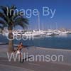 GW34656-60 = Young lady roller blading along Paseo Maritimo past luxury yacht marina with Palma Cathedral in the background, Palma de Mallorca / Majorca, Balearic Islands, Spain. 13th August 2009. Model Release.